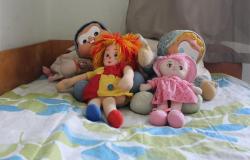 Quatro bonecos de pano em cima de uma cama