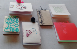 Seis cadernos de material reciclado dispostos em uma mesa